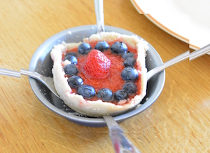 Tarta acabada de salir del horno, sujetada con cubiertos para sacarla del molde
